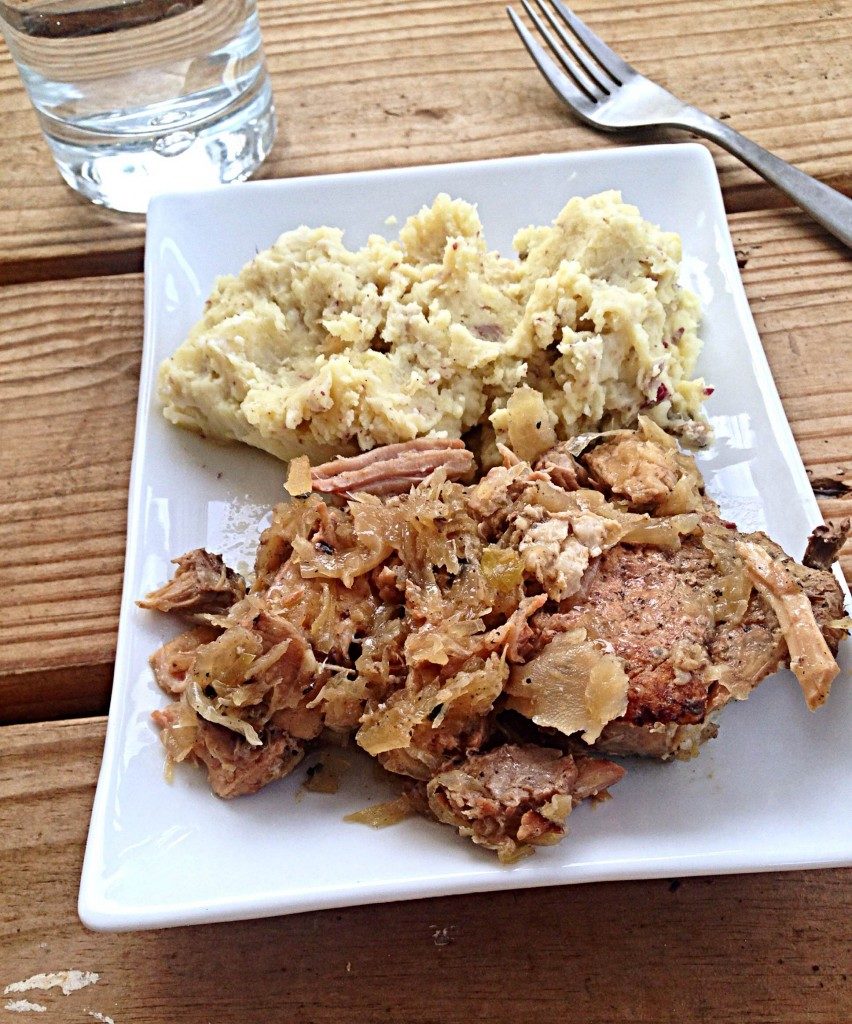 pork chops with bacon and sauerkraut on plate with smashed potatoes