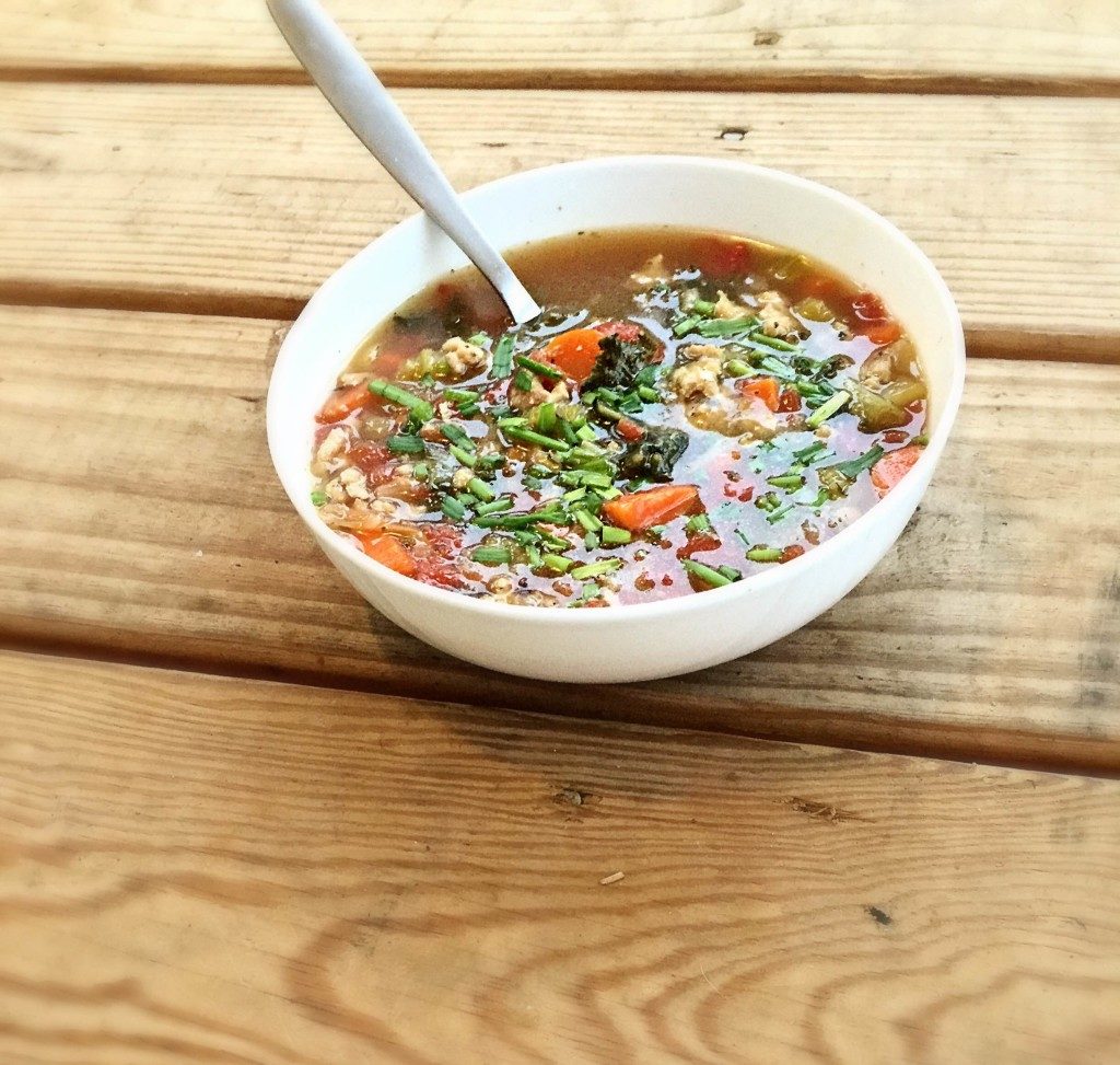 spicy sausage kale soup in bowl with spoon