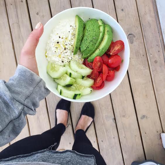megan holding bowl with egg salad, cucumber, tomatoes, avocado