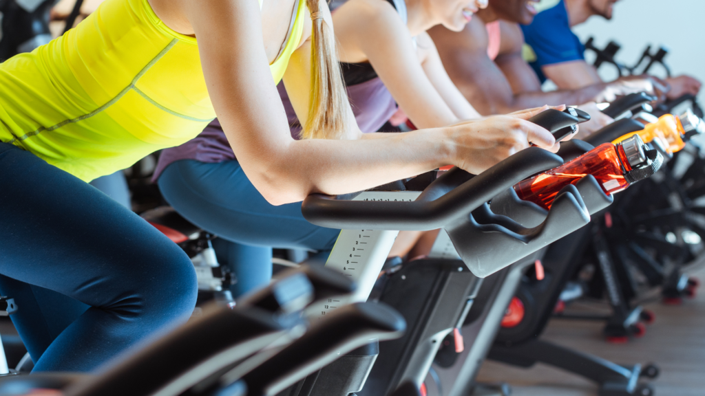 men and women working out on exercise bikes 
